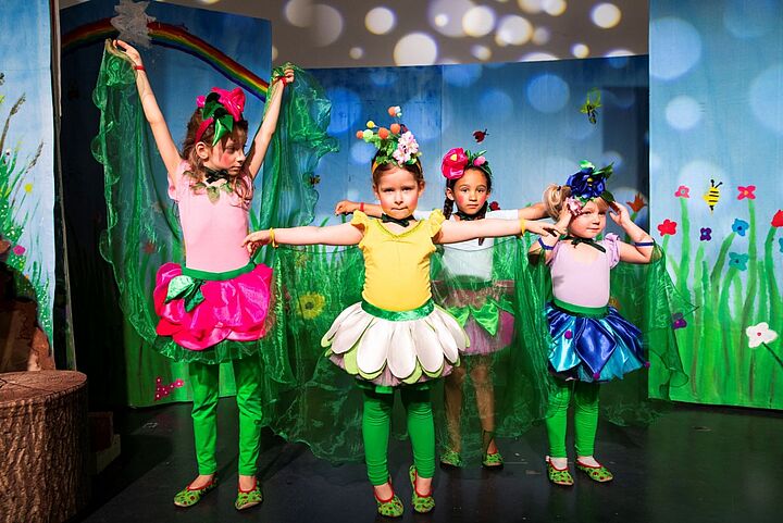 Vier Kinder in Kostümen bei der Aufführung von Aponi